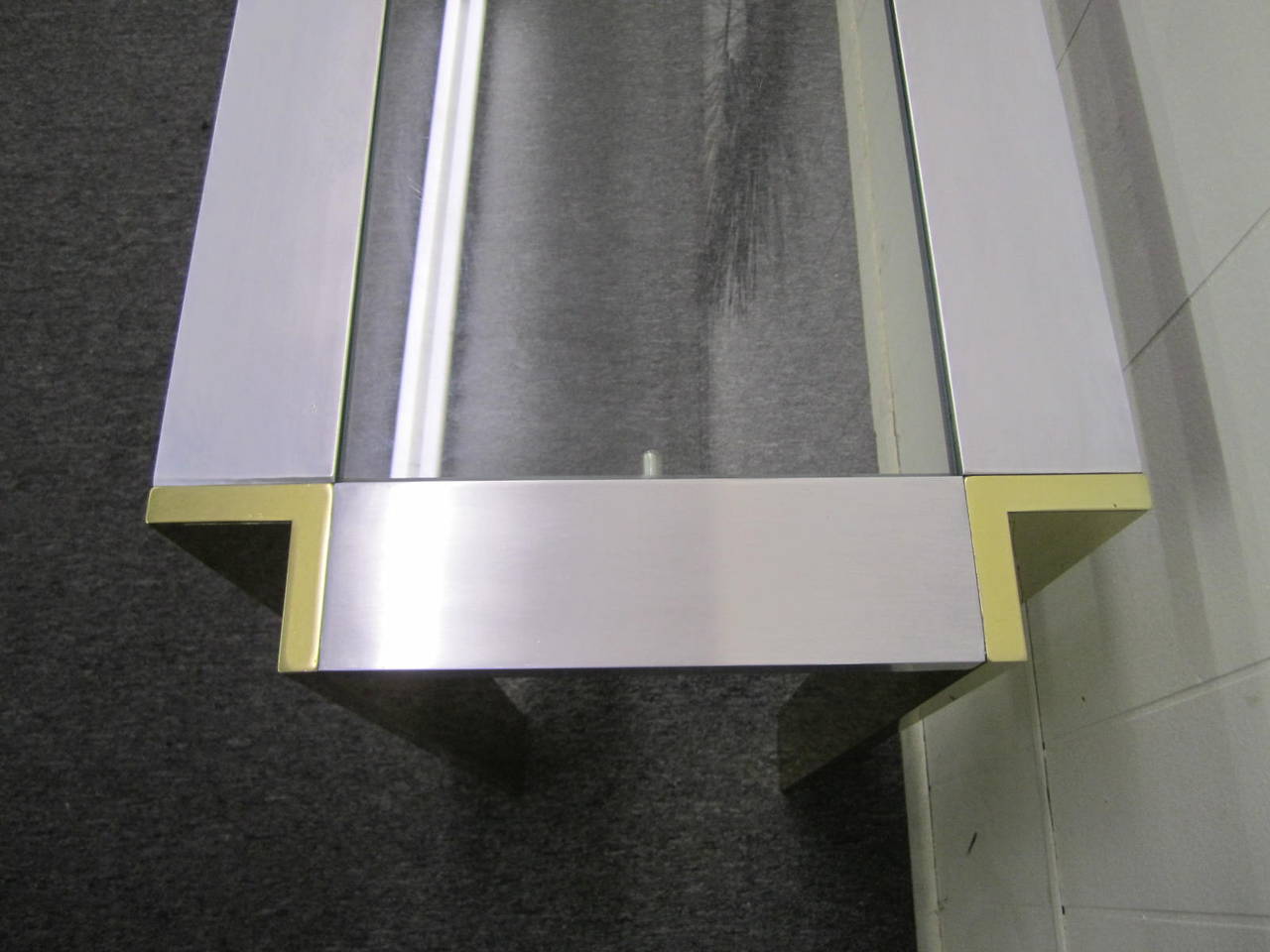Great looking brushed aluminum and brass Romeo Rega console table. We love the use of the aluminum and the brass together very unusual. The table shows only light wear with a few light scuffs and dings-nothing serious or distracting.