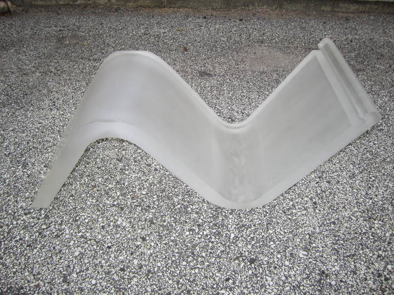 Magnifique table basse en lucite épaisse dépolie à la vague simpliste.   Le verre biseauté en angle repose sur un ruban épais et lourd de lucite givrée.  L'un des bords du verre biseauté s'insère dans une fente le long du bord supérieur de la grosse