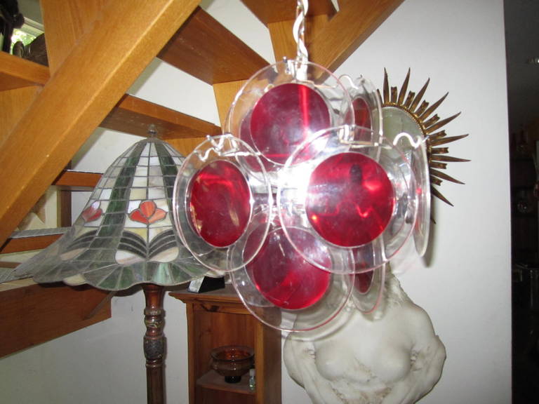 Lovely petite Vistosi style red and clear Lucite disk chandelier. Whimsical and fun Lucite disks on a simple metal frame. The clear disks with red inserts are in great condition, looks even nicer in person. Great for a powder room or small hallway.