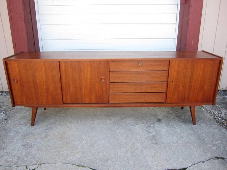 Marvelous mid-century Danish modern teak credenza with sliding doors and 4 drawers.  Perfect for your dining room or tv room-great storage options.