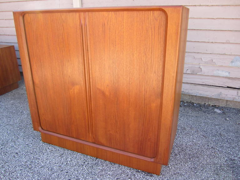 Handsome Bernhard Pedersen & Son tamboured door teak tall dresser.  Well designed with tons of storage options and lovely tamboured doors to hide it all.  I love the rounded ends and plinth base you will too. This piece is also finished on the back