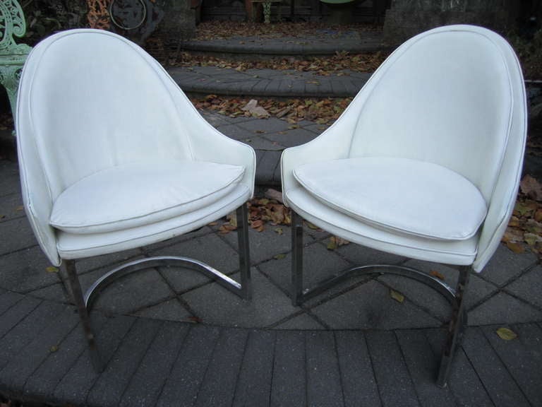 Lovely set of 4 Harvey Probber style white vinyl and chrome dining chairs.  They each have a fantastic spoon shaped barrel back done in a very nice original white vinyl.  There are no labels but they were purchased from an estate full of signed