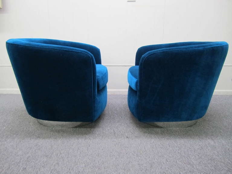 Outstanding pair of Milo Baughman chrome base swivel lounge chairs.  These chairs are in pristine restored condition.  The upholstery is a fabulous shade of aquamarine blue velvet-really gorgeous in person.  The chromed bases have been restored with