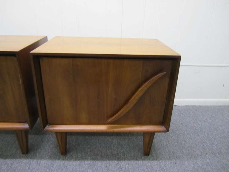 Lovely pair of american modern walnut night stands.  Very interesting details with large sculptural pulls and nicely carved legs.  I have the matching tall dresser and credenza if your looking for additional pieces.