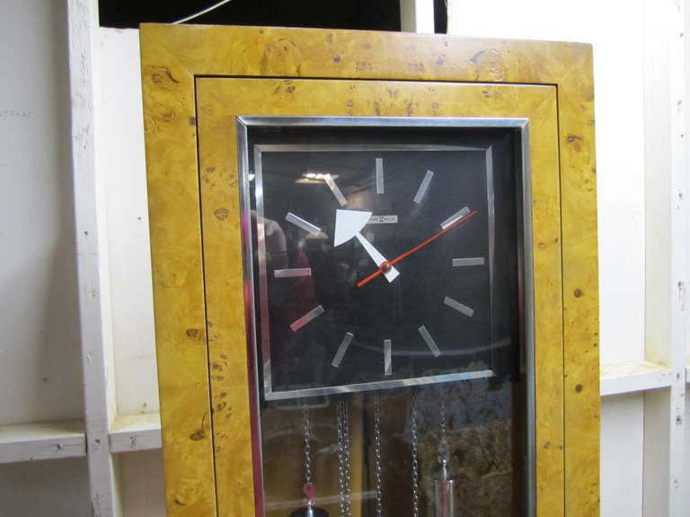 Wow is what you will say when you see this gorgeous mid-century modern tall clock by Howard Miller.  Stunning olivewood and chrome adorn this modern tall grandfather clock.  You will love the combination!  This clock is in perfect working order and