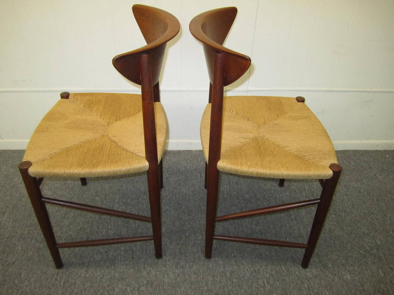 Excellent pair of Hvidt Molgaard teak dining chairs with newly rushed seats.  The chairs have a lovely timeworn honey brown patina and are tight and sturdy.  We do have a matching pair of arm chairs if your looking for more pieces to this collection