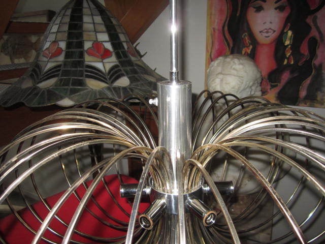 GORGEOUS POP MODERN GAETANO SCI0LARI CHROME AND BRASS BIRDCAGE HOOP CHANDELIER.  THIS PIECE TAKE 6 CANDELABRA BASED BULBS AROUND THE CENTER AND ONE STANDARD BASE REFLECTOR BULB FOR DOWN LIGHT.  THE DOWN LIGHT CAN BE TURNED ON BY A SWITCH THAT IS