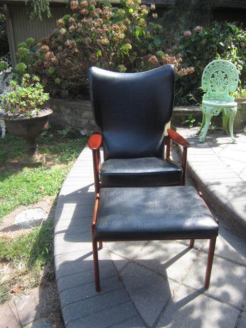 Fabulous Danish Modern signed Moreddi reclining teak lounge chair with ottoman. The chair is upholstered in black faux leather and is in great condition. The ottoman is done in leather and does show some minor wear. There are different labels on