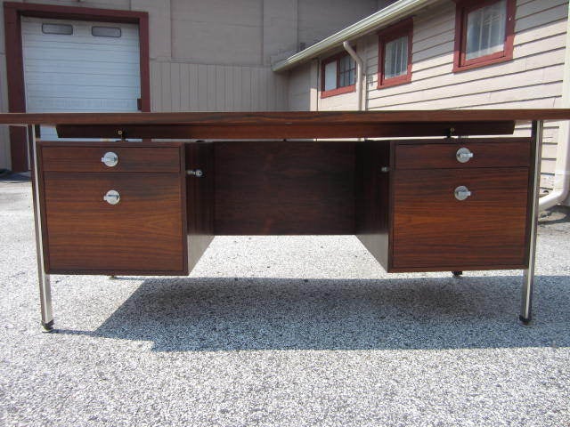 Fabulous Danish modern signed Finn Juhl rosewood diplomat desk. This piece is in fantastic vintage condition. The top has beautiful dark rich rosewood graining with only light wear. The legs are very architectural with a combination of rosewood and