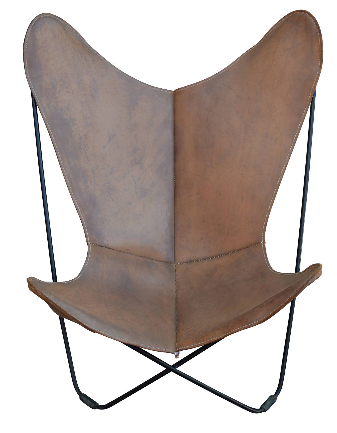 A super cool and cozy pair of butterfly chairs in thick tan leather, horse-saddle feel to them. Unique patina and black painted metal frame.