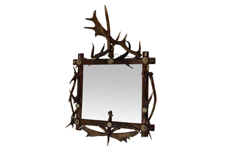 A wonderful antler mirror with six detailed carved medallion of game.