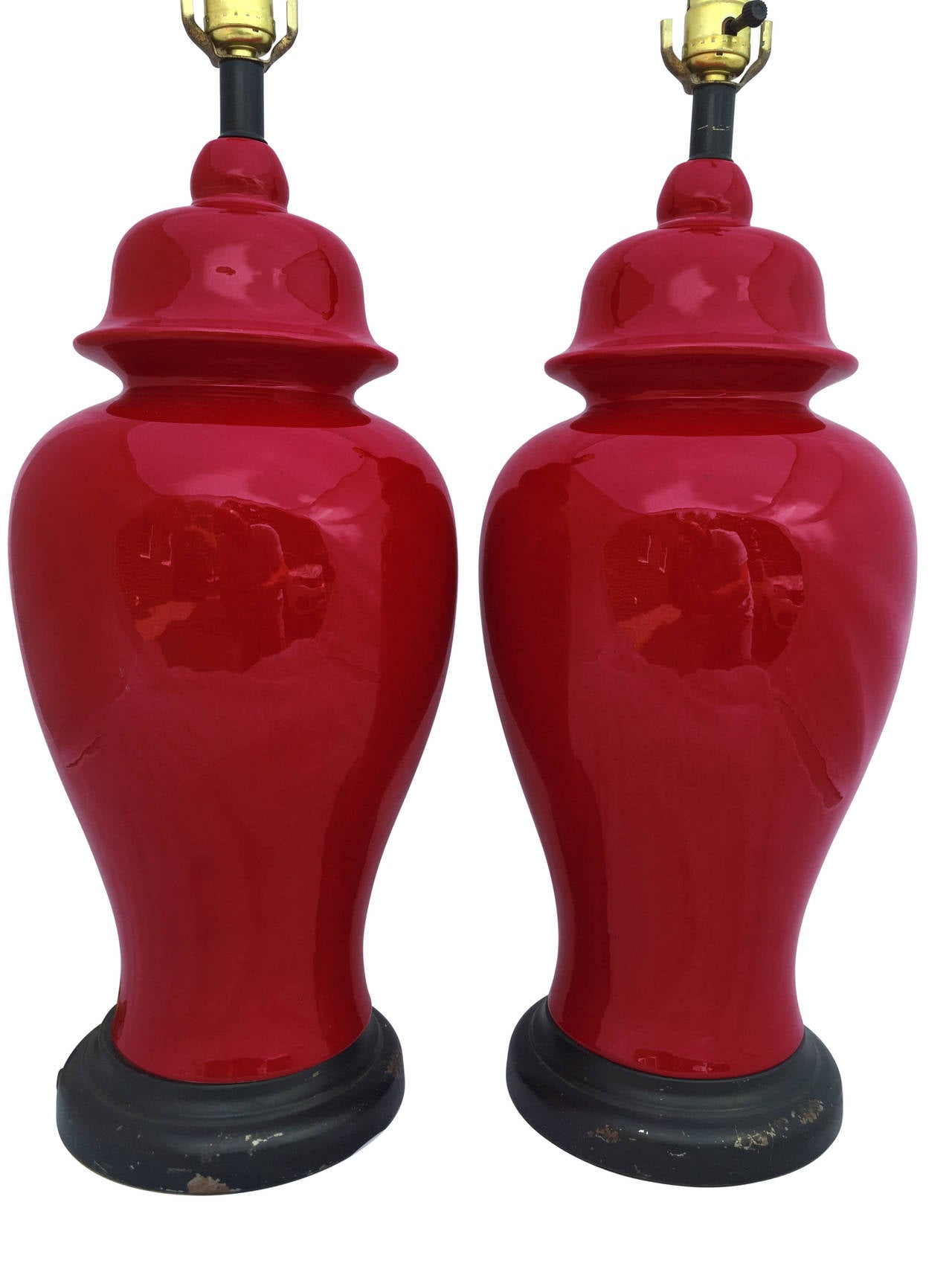 This is a gorgeous pair of Mid-Century ginger jar lamps. The red is a bold, deep blood red. The black painted metal bases have some wear, showing their authentic age. Newly wired with UL listed approved parts.