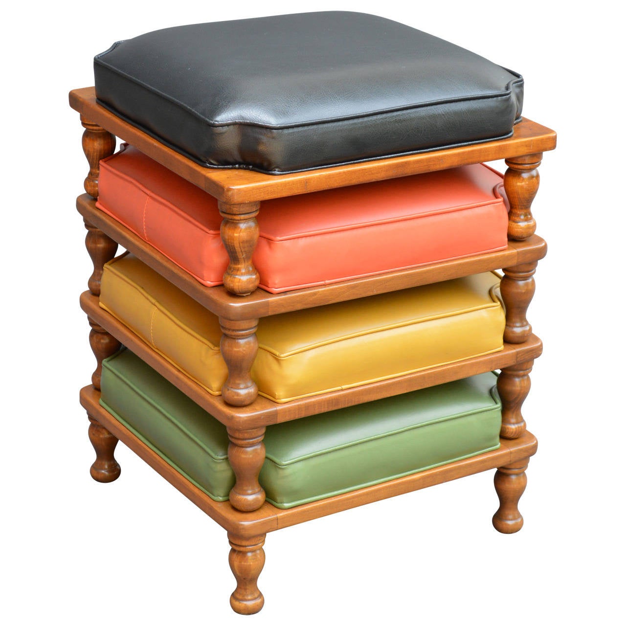 Cool set of four Ethan Allen stacking ottomans from the 1970s! The original Naugahyde cushions are very versatile in black, orange, yellow and green and sit atop a medium wood finish. Labeled Ethan Allen American traditional.