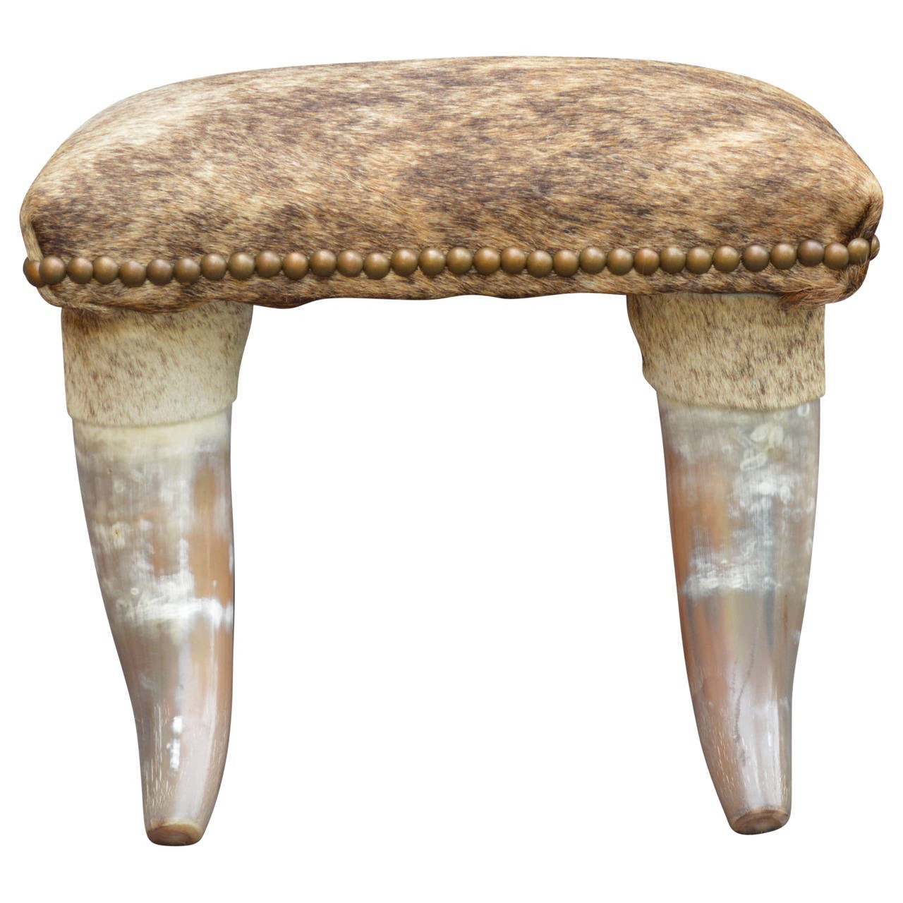 Beautiful longhorn footstool with brindle cowhide cover in shades of brown, accented with antiqued brass nailheads.