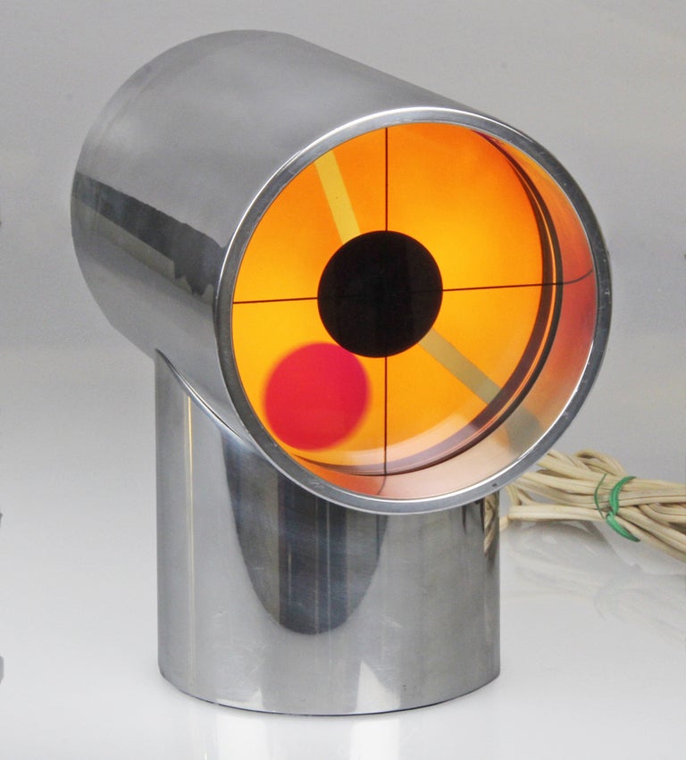 This is a  vintage clock in a cylindrical aluminum housing.
The large red dot spins around the face as the second hand. The face pulses color from a yellow to a blue-green face.