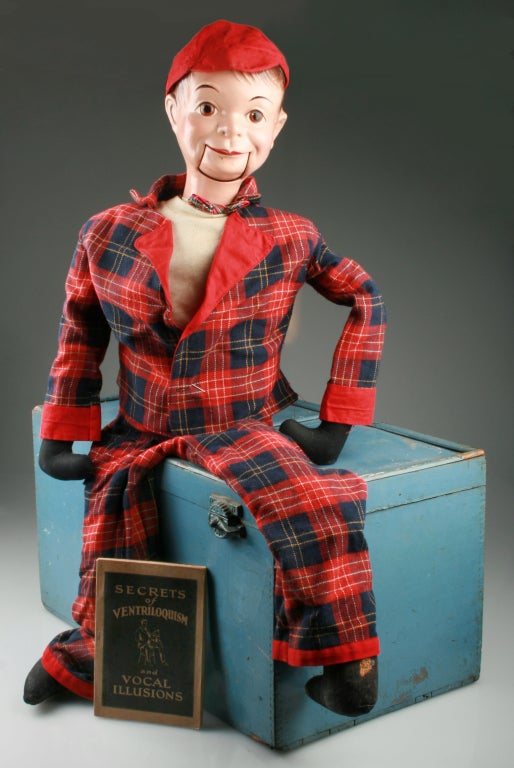 Puppet with movable mouth in original clothing and stufed with 
wood fiber. Wooden storage box measures 23 