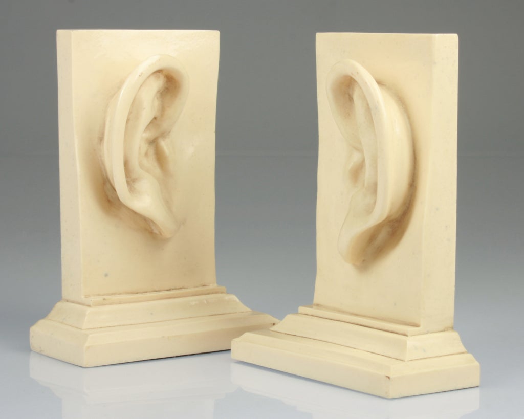 These are fun and eccentric bookends, bearing a left and right ear.  They are each signed, but the signature is illegible.