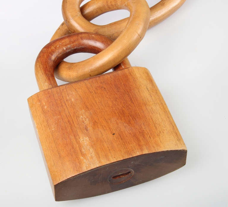 This is a large sculptural piece consisting of  a chain of interlocking wood links, a hook and a padlock.  The padlock measure 6.5 