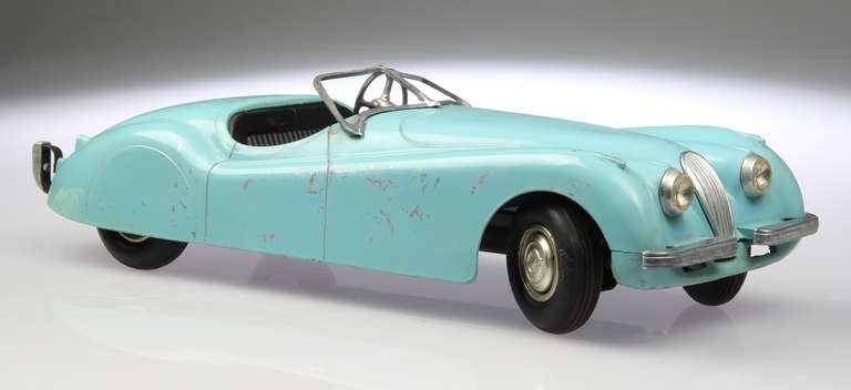 This Jaguar Roadster, from the 1950's, was manufactured by Model Toys in Rossmoyne Ohio, USA.
The wheels are rubber and are marked Doepke and Model. The front wheels turn via the steering wheel.