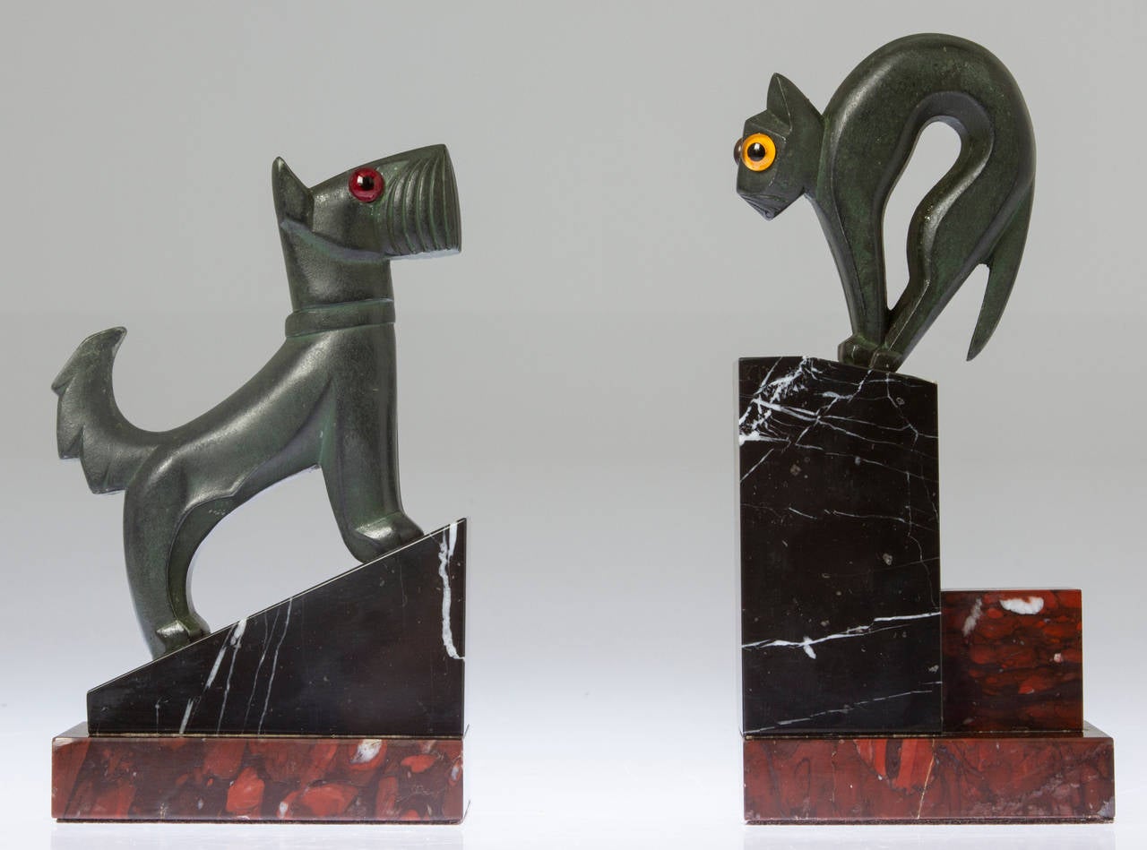 What a great pair of bookends depicting a meeting between a cat and dog on marble bases. The animals have glass eyes and a bronzed patina over white metal. The measurements are as follows:
Cat dimensions: 8.5 high, 3 deep, 4 wide.
Dog dimensions: