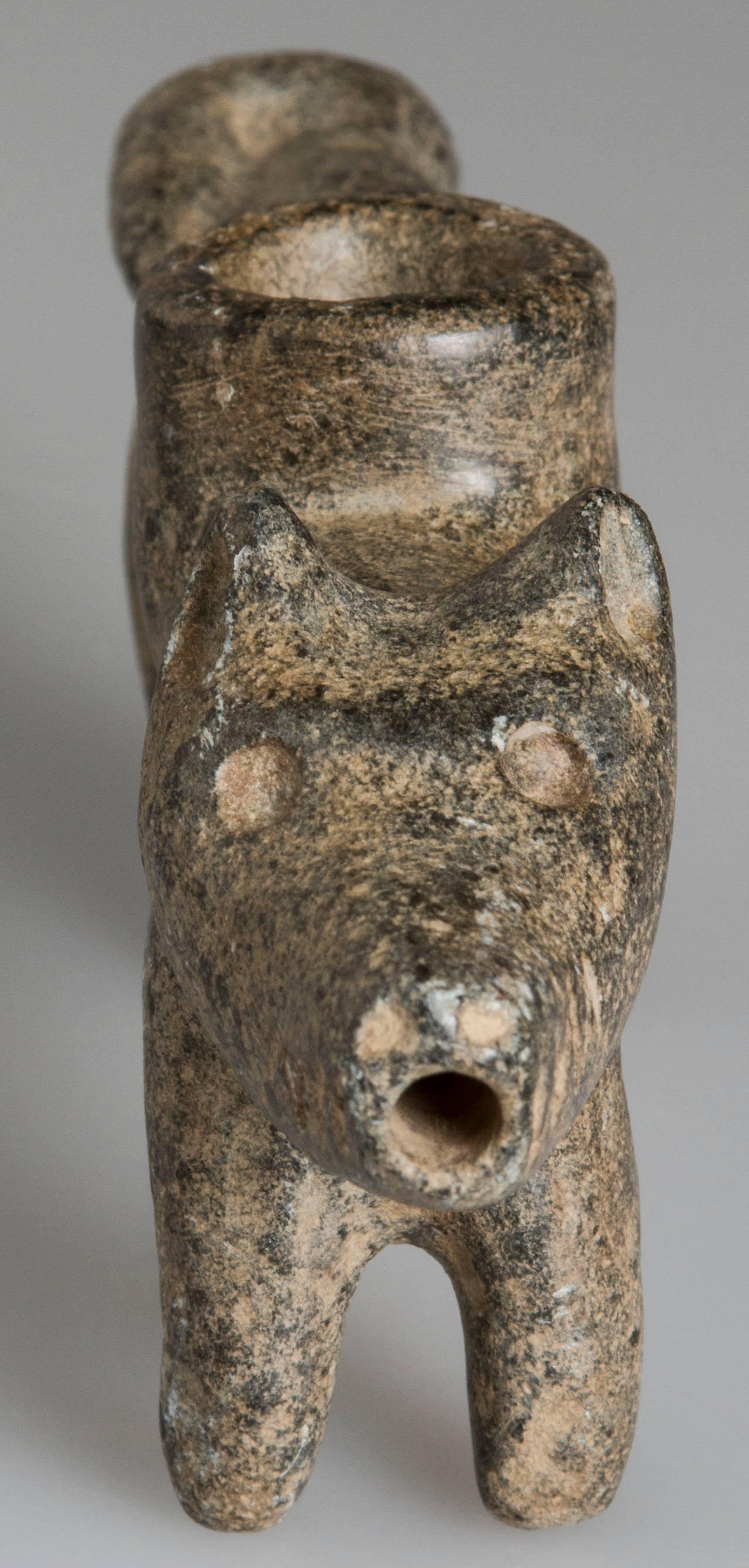 This is a hand-carved figural pipe with a hole in the mouth and the bowl is on top.