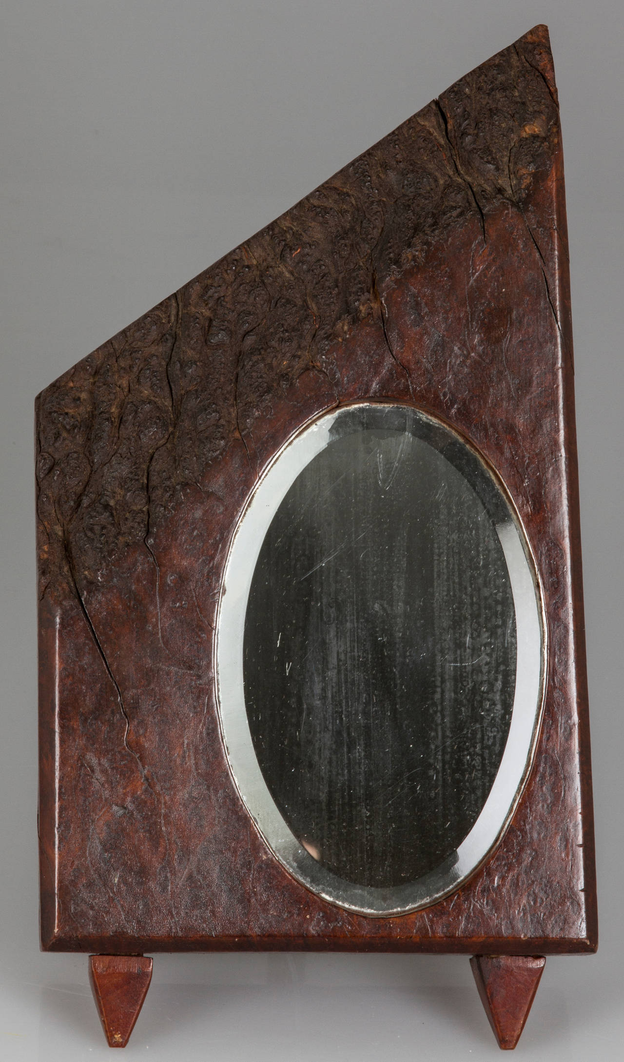 Hewn from a solid block of wood, this is an interesting tabletop mirror.