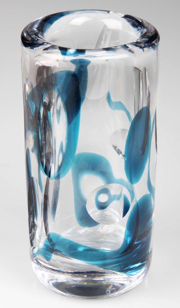 This is a very optical vase,  with thick walls with wheel cut ovals and circles accented with blue.
It is sIgned on the bottom Kosta 46693, Lindstrand.