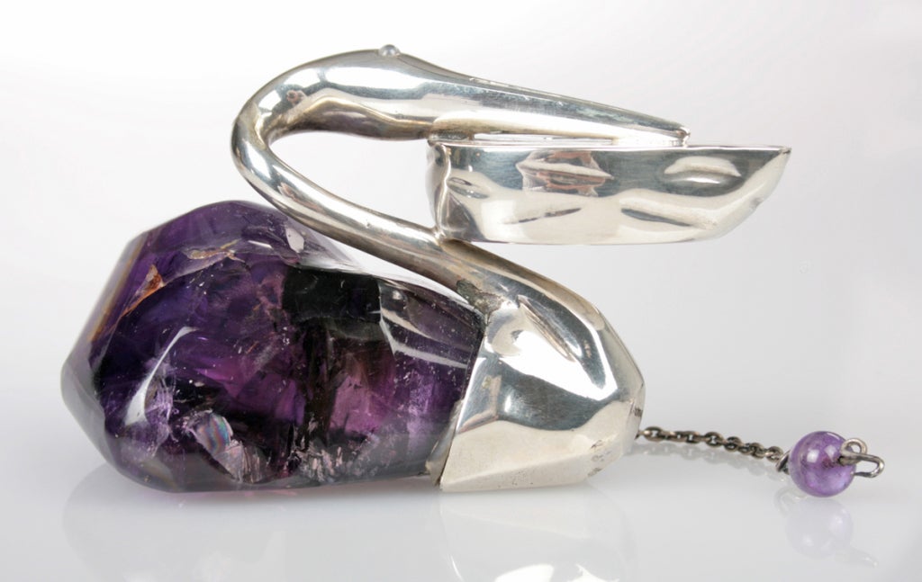 This is a wonderful cigar lighter in the form of a swan or pelican, the body being amethyst quartz.  The oil was poured underneath the opening under the amethyst bead and the wick came out through the hole in the vessel the bird is resting its head