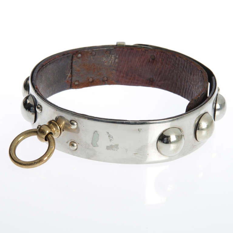 This collar is embellished  with half spheres and a lock and key.
The total length is 23.25 inches.