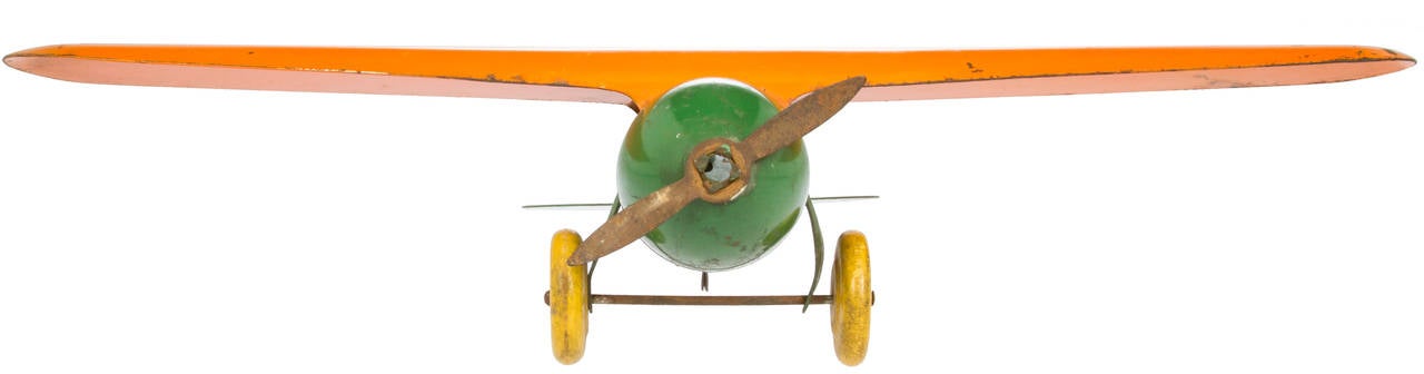 This is a great example of a 1930s tin plane, having great colors and wooden wheels.