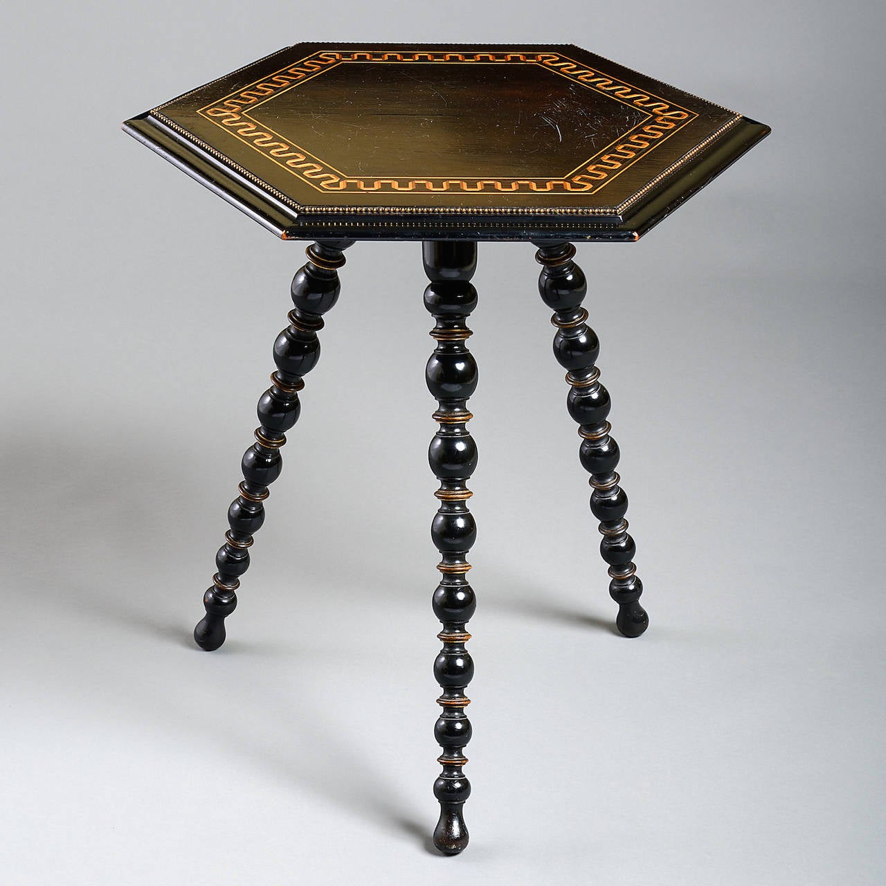 A fine Victorian ebonized and parcel-gilt gypsy table, the hexagonal top with geometrically inlaid tunbridge ware band, circa 1860.