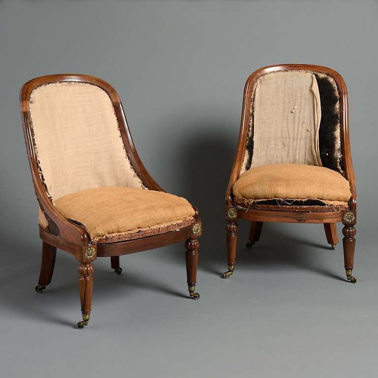 A pair of Regency rosewood bergeres with turned legs headed by gilt-brass paterae.  Circa 1820.