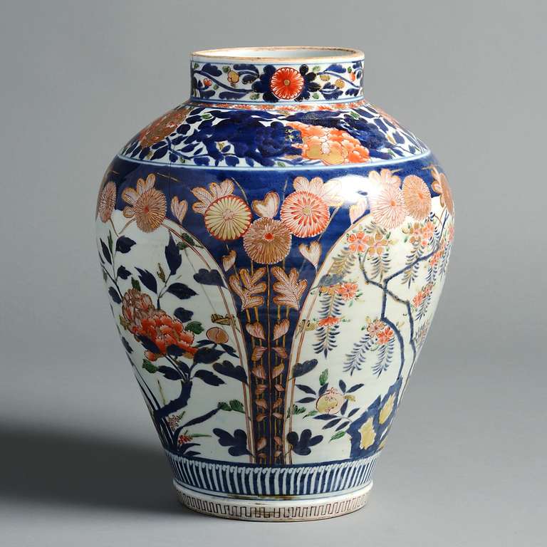 A fine Japanese Imari vase decorated in cobalt blue, iron red, green and gilt.  The frieze decorated with dragons, the body with flowering branches within an arcaded pattern, early 18th century.