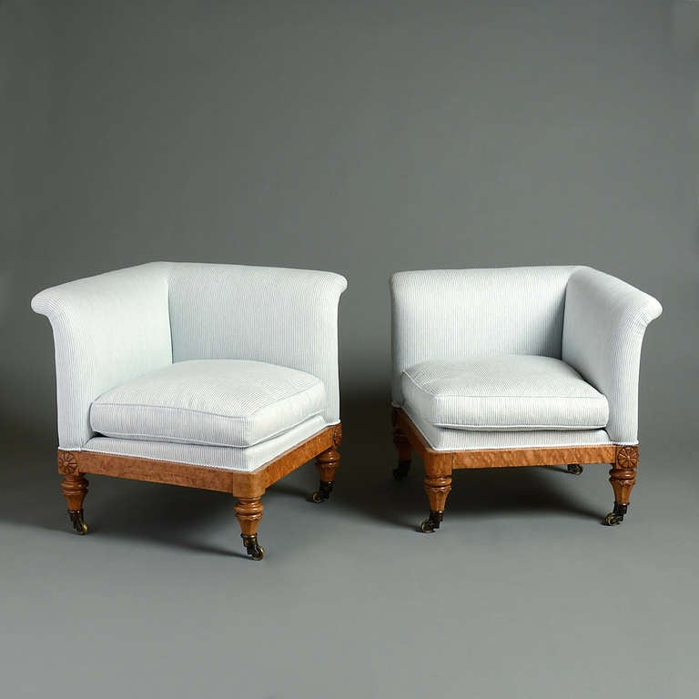 A pair of William IV burr-maple corner chairs on faceted tapering legs with patent castors, circa 1830.
