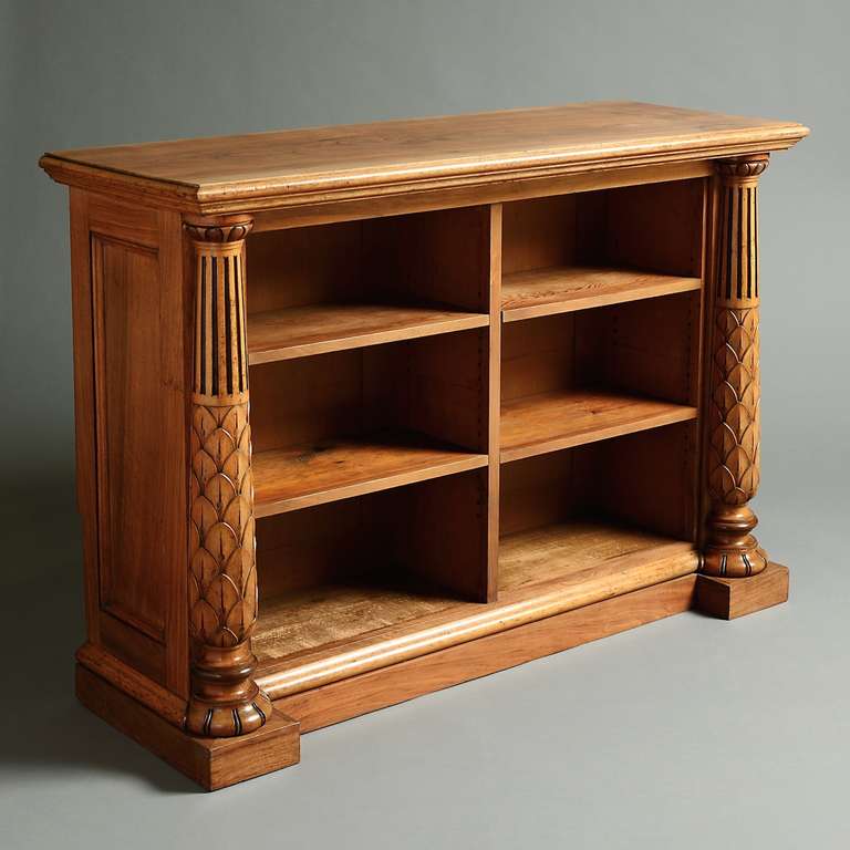 AN EARLY VICTORIAN WALNUT AND OAK OPEN BOOKCASE BY HOLLAND & SONS, STAMPED HOLLAND & SONS, CIRCA 1860.
With adjustable shelves flanked by massive columns carved with overlapping leaves.