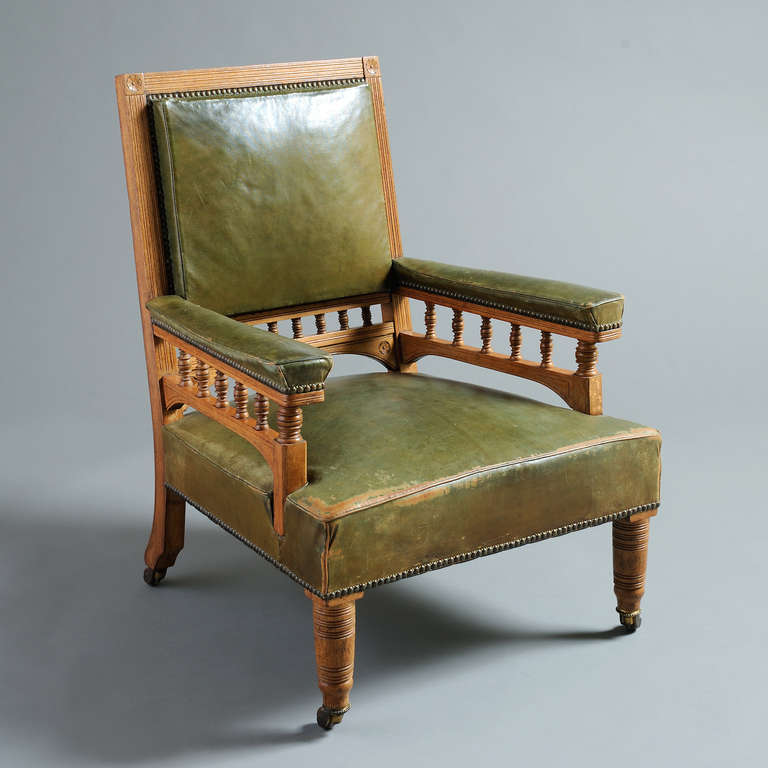 A fine late Victorian oak library armchair with original green leather upholstery, circa 1880.