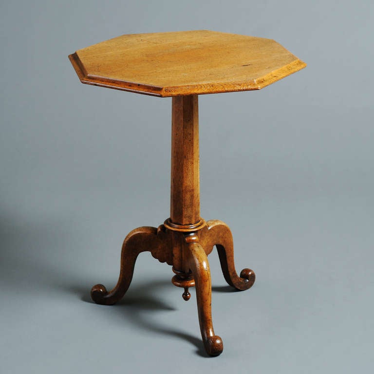 an early Victorian golden oak tripod table with octagonal top and faceted column, circa 1840.