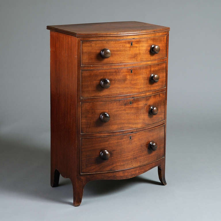 A fine late Regency mahogany bow-front chest of unusual proportions, original turned handles, circa 1820.