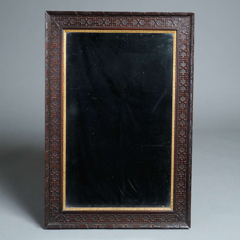 A fine and unusual george III parcel-gilt mahogany mirror with original bevelled plate, circa 1760.<br />
The blind fret-carved frame with ribbon-tied border carved with paterae on a pounced ground.