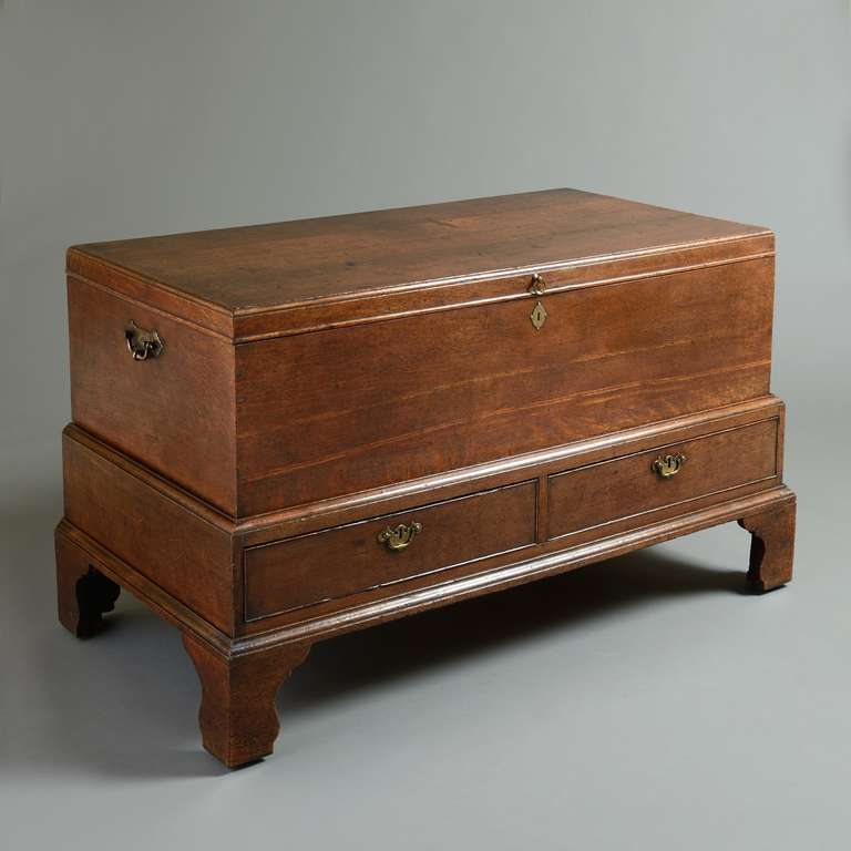 A George I oak mule chest, circa 1725. With hinged top above two drawers on bracket feet, original handles, those to the side with engraved back plates.