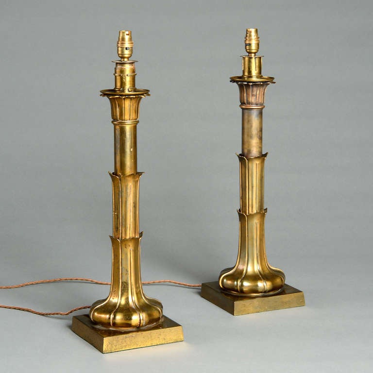 An unusual pair of early Victorian lacquered brass table lamps each with a lappeted lotus leaf column and square base, circa 1850.
