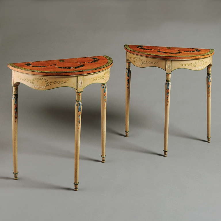 A RARE PAIR OF GEORGE III PAINTED AND SATINWOOD PIER TABLES, IN REMARKABLY ORIGINAL CONDITION, RETAINING ALL THEIR ORIGINAL PAINTED DECORATION, CIRCA 1790. 
Each with demi-lune satinwood top painted with ribbon tied floral swags, the border painted