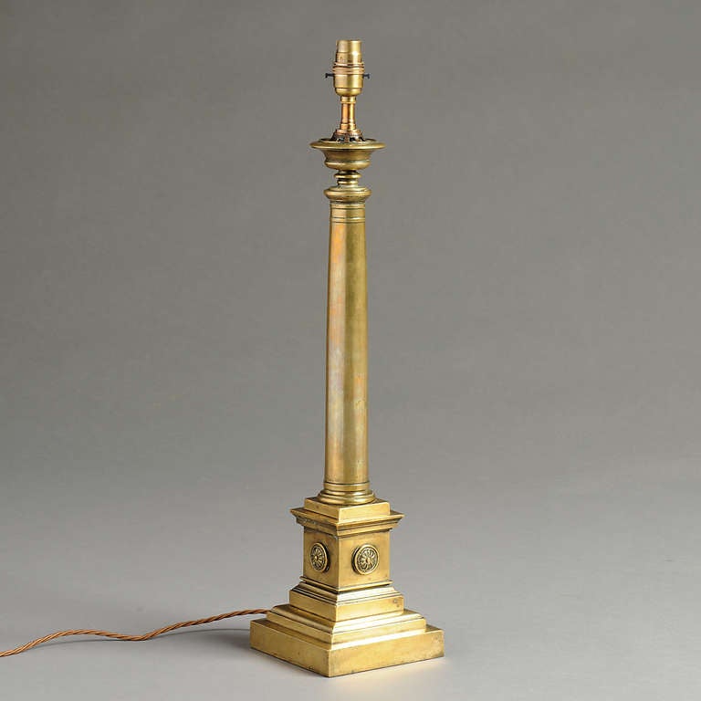 A FINE LATE REGENCY LACQUERED BRASS COLUMN LAMP ON A SQUARE PLINTH APPLIED WITH PATERAE, Circa 1830.