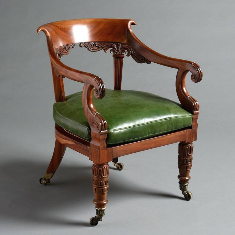 a George IV Goncalo Alves armchair attributed to Gillows, circa 1825.
Carved with lotus leaves and scrolls with curved scroll-over top rail, the original seat squab re-upholstered in green Morocco leather, the legs with original ribbed socket