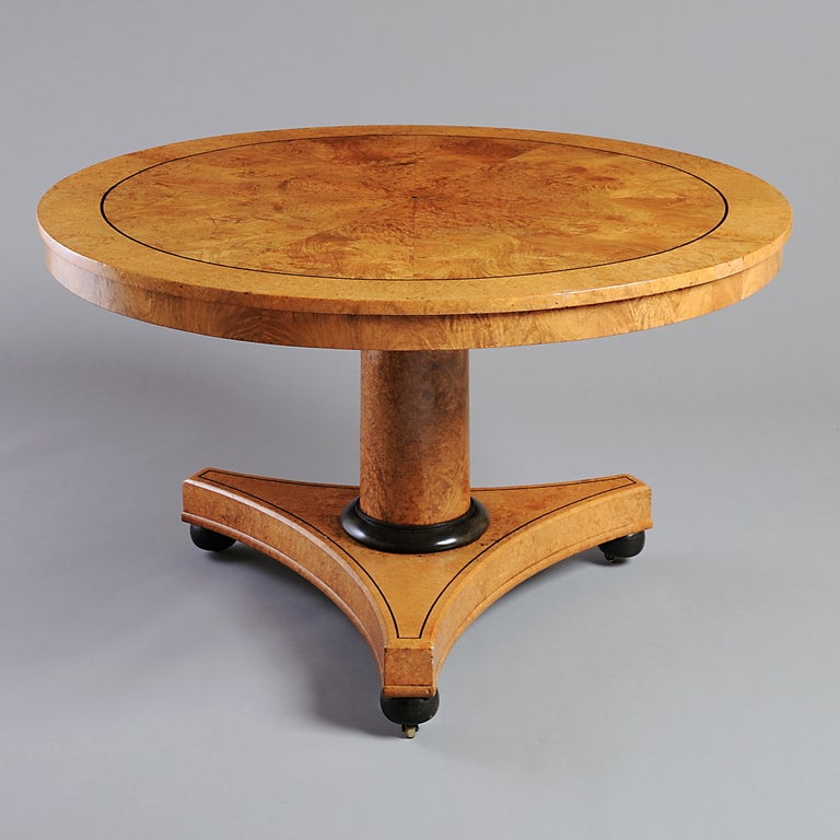 A FINE REGENCY AMBOYNA CENTRE TABLE, CIRCA 1820.
With radially veneered tilt-top on a concave base with ebonised feet.