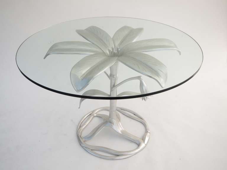 Glass top table with a sculptural base in the form of a lily.