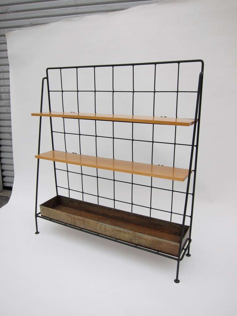Unique display shelves made by the Inco Company, designed attributed to Milo Baughman. Shelves made of solid maple, both adjustable. The bottom of the unit has a brass planter box. Black iron structure.