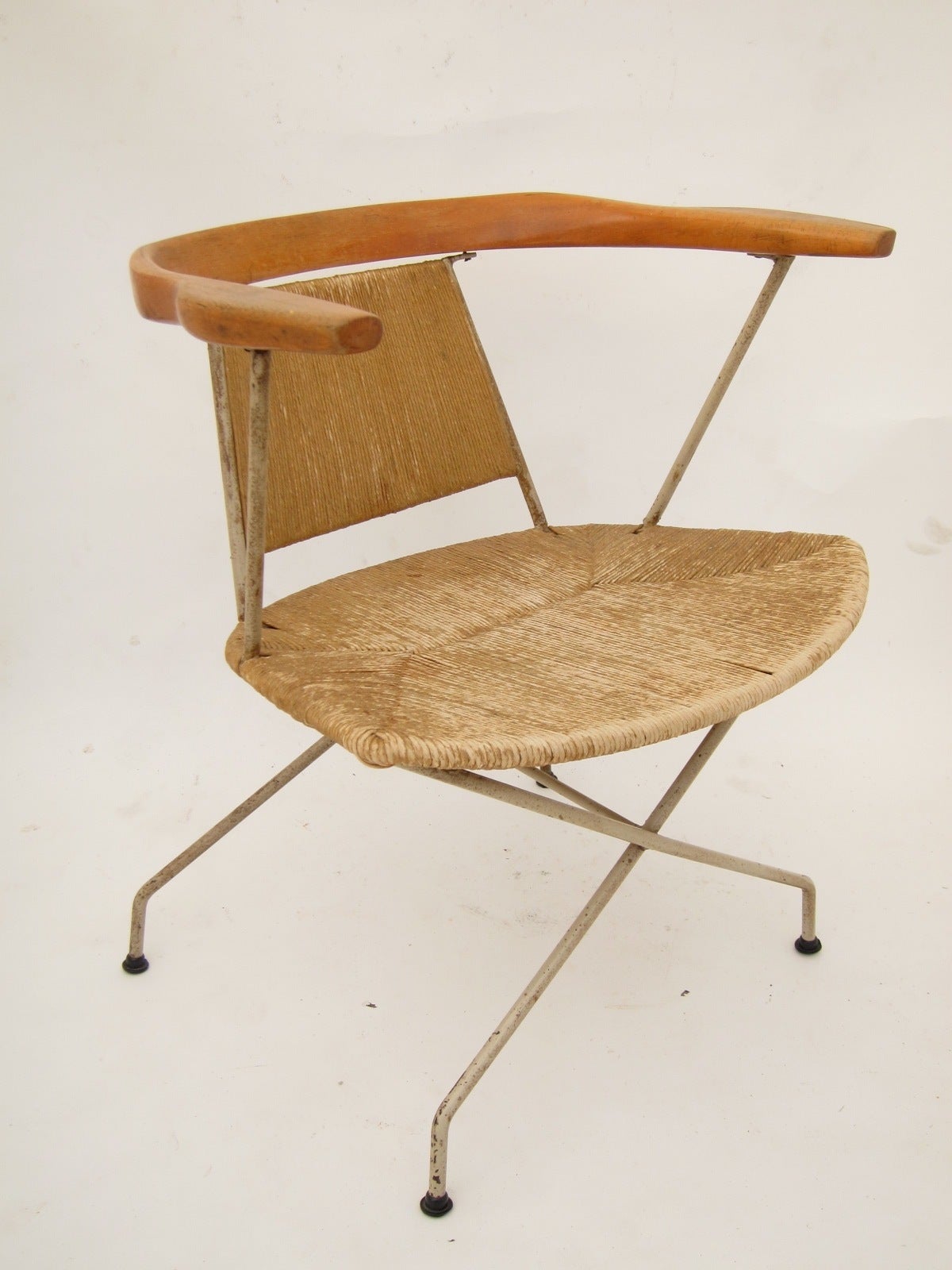 Iron frame arm chair with rope/rush seat and sculpted wood back and arms. 
Designed by Arthur Umanoff for Raymor.
