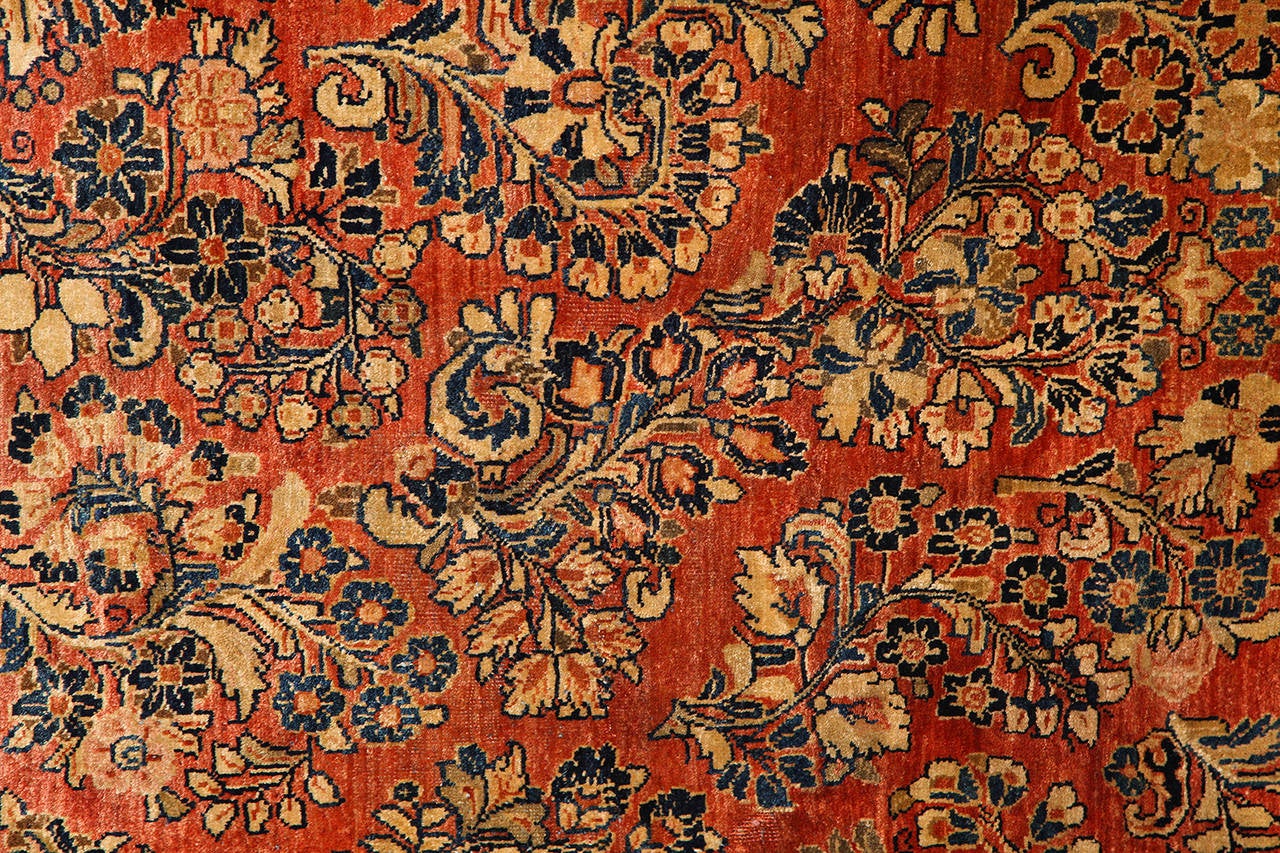 This Persian Sarouk carpet created, circa 1910 consists of a pure wool hand-knotted pile, cotton warp and thread and natural vegetable dyes. Unlike many other existing Sarouks from this time period, the deep reds, golds, blues and blacks of this