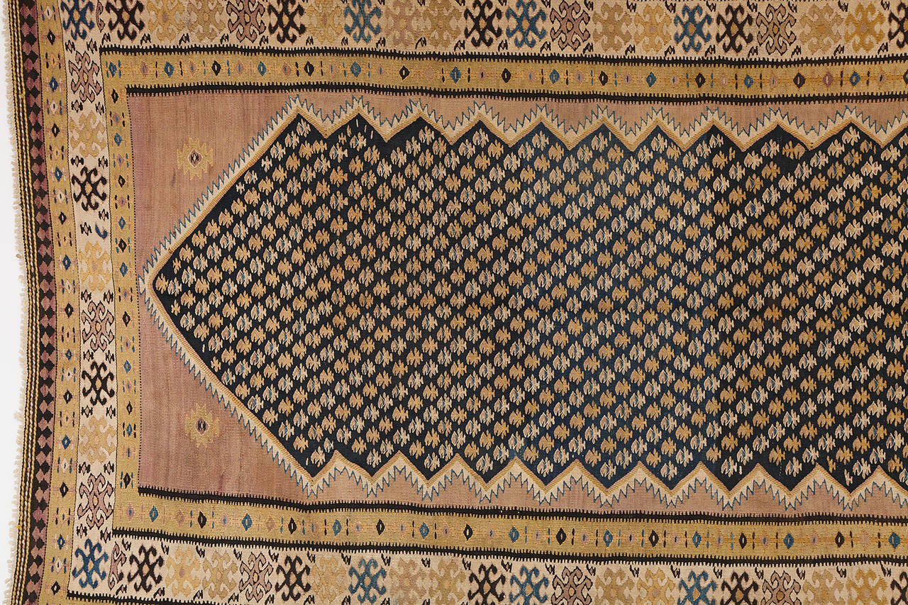 This Persian Bidjar Kilim created, circa 1890 consists of pure wool and natural vegetable dyes. It exhibits unique colors for a carpet of its kind, with soft earth tones accented by black, gold and blue. Its size is also very rare, measuring 4'9
